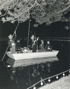 603522 Afbeelding van een bootje met in Franse kostuums gestoken muzikanten in de vijver van het Wilhelminapark te ...